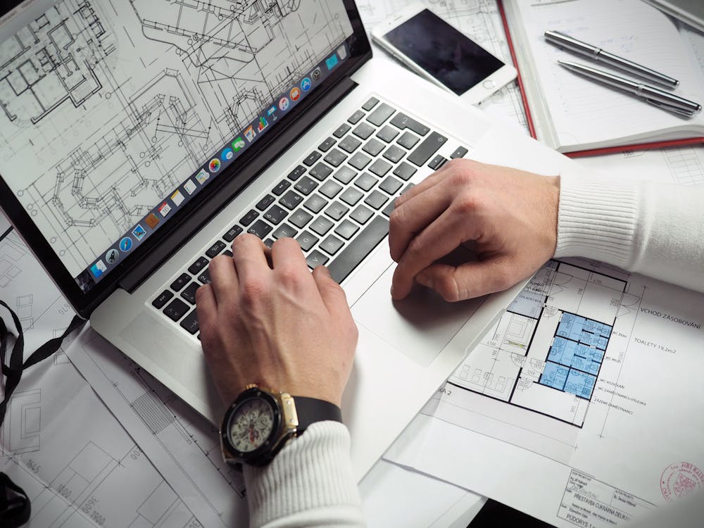 person working on laptop, refining blueprints